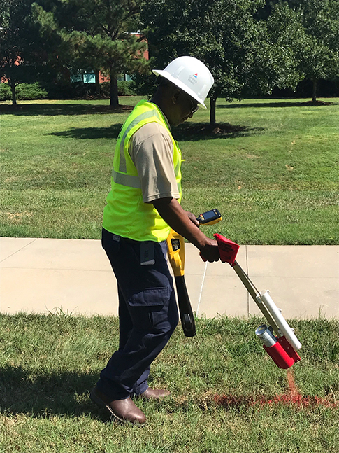 Georgia Power employee marks the area of underground lines with spray paint.