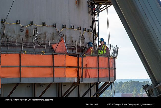 Workers perform welds on Unit 3 containment vessel ring